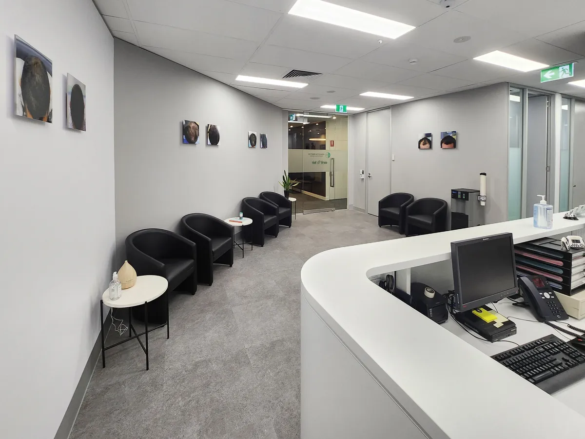 Reception desk with computer workstation and waiting seating along corridor at the Ashley & Martin cosmetic clinic fitout, Southbank.