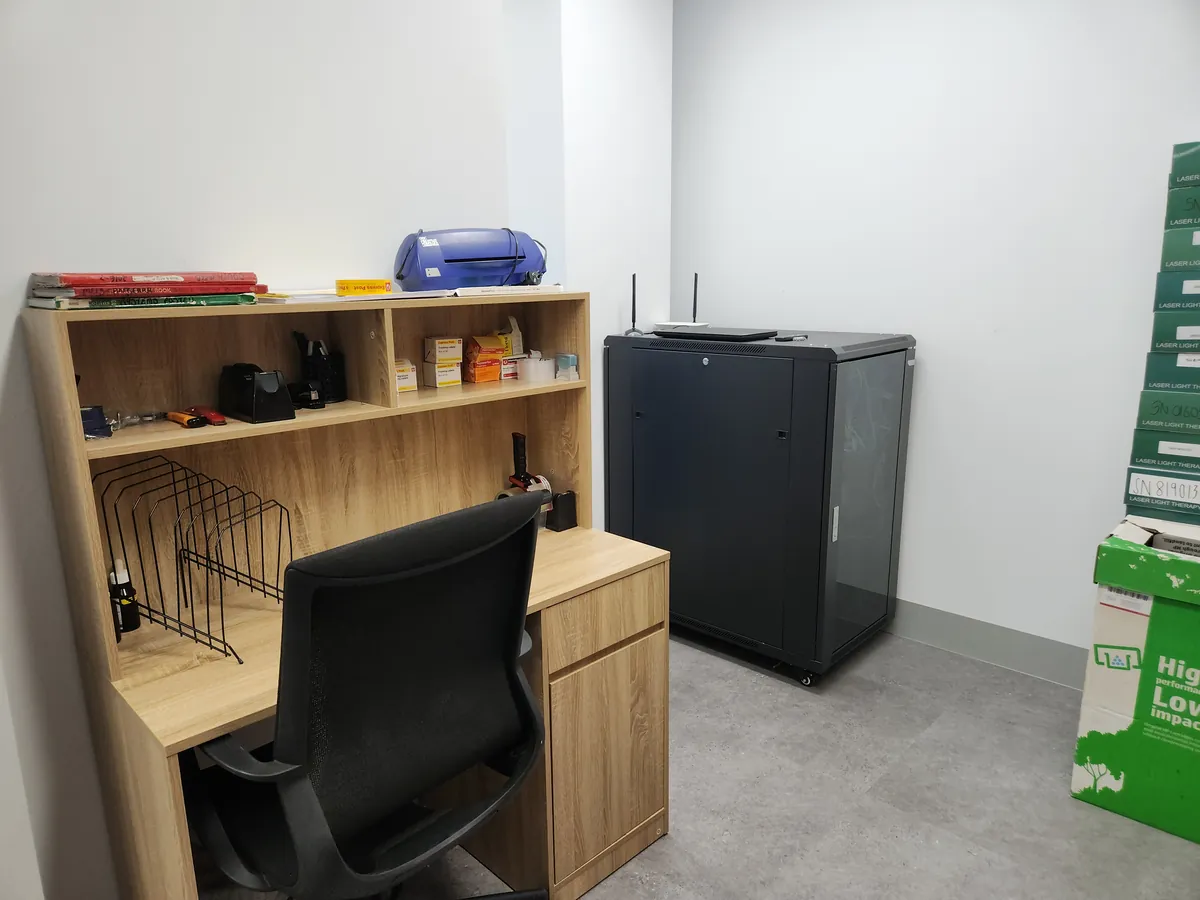 Storeroom with timber desk joinery and comms server rack at the Ashley & Martin cosmetic clinic fitout, Southbank.