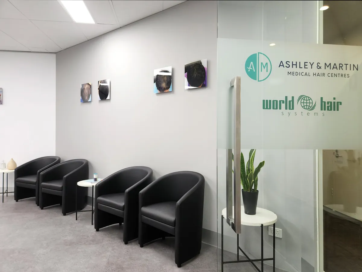 Waiting area with black tub chairs and branded glazed signage at the Ashley & Martin cosmetic clinic fitout, Southbank.