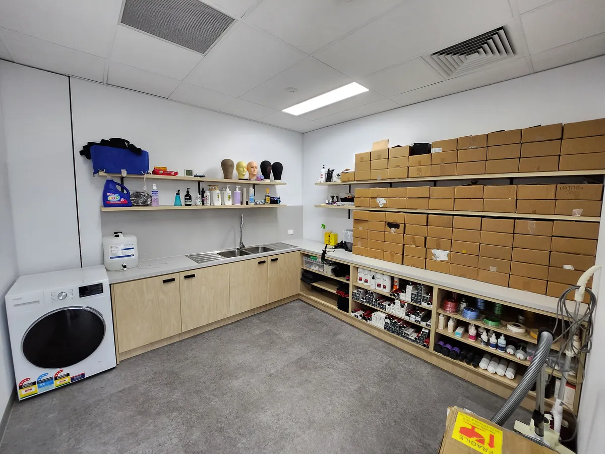 Hairpiece workshop with custom joinery, sink and product shelving at the Ashley & Martin cosmetic clinic fitout, Southbank.