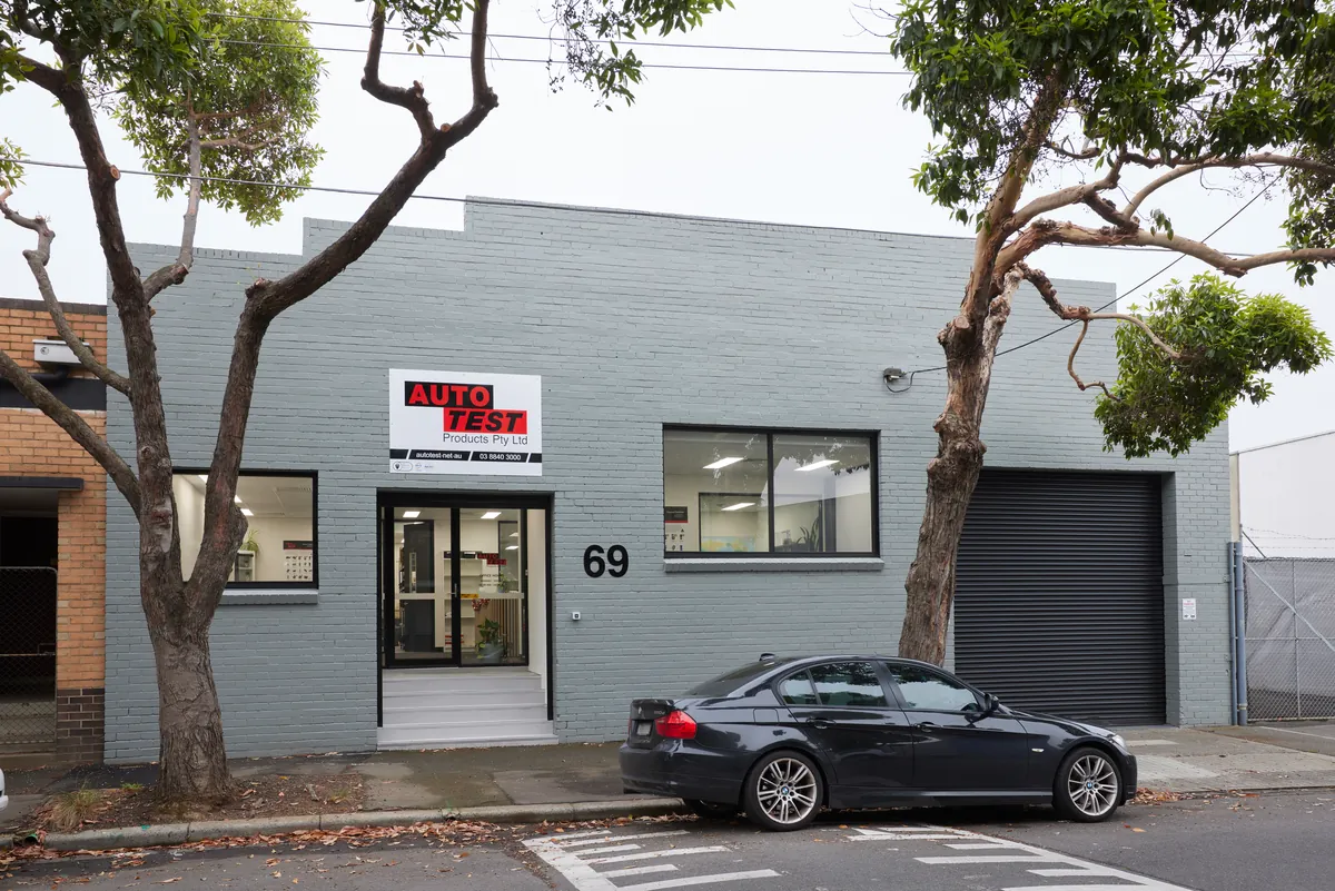 Street view of the painted brick facade and entrance, Autotest warehouse-to-office conversion, Kensington.