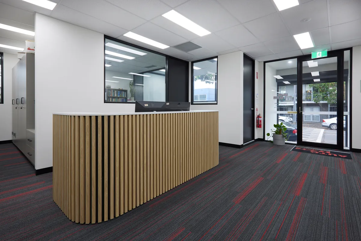 Reception desk with timber batten joinery, Autotest warehouse-to-office conversion, Kensington.