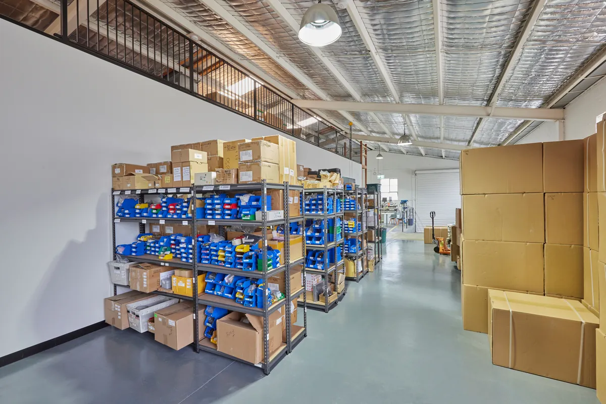 Warehouse with stock shelving, bins and mezzanine above, Autotest warehouse-to-office conversion, Kensington.
