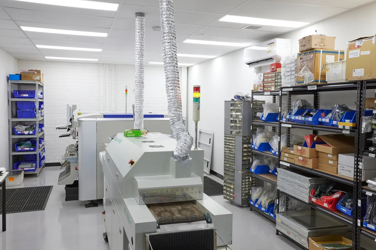 Assembly workshop with reflow oven and parts shelving, Autotest warehouse-to-office conversion, Kensington.