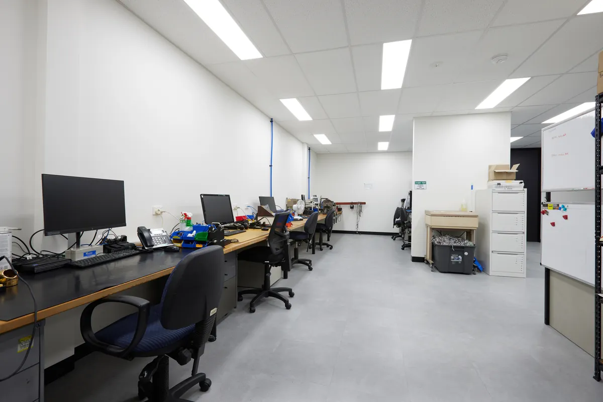 Open-plan office workstations with desks and monitors, Autotest warehouse-to-office conversion, Kensington.