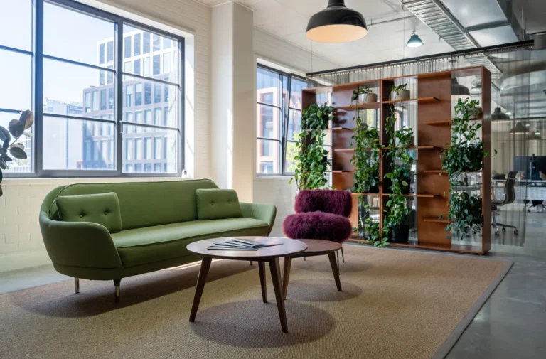 Breakout lounge with green sofa and biophilic planted screen, Clinibase office fitout, Collingwood.