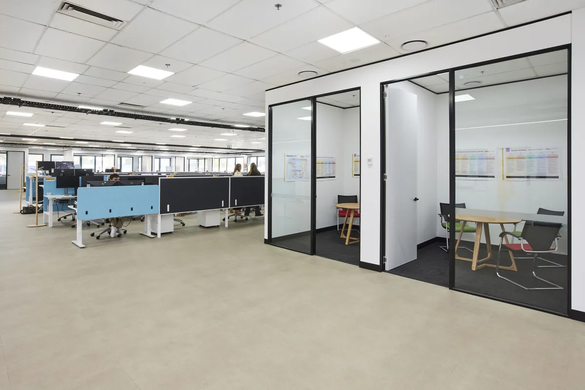 Glass-partitioned meeting rooms beside open-plan workstations at the CPB Contractors office fitout, Blackburn North.