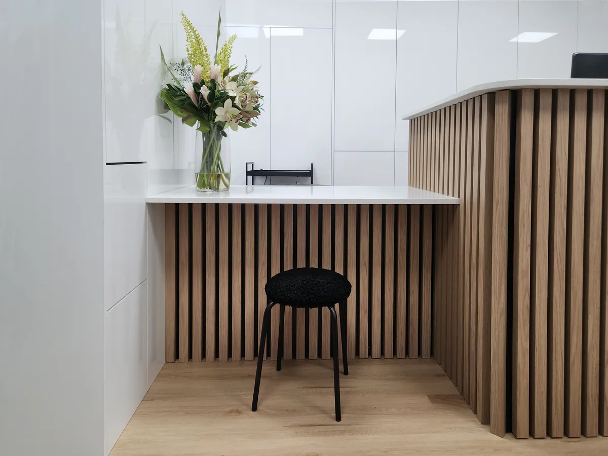 Timber batten and stone reception desk detail at the Creative Smiles dental clinic fitout, Armadale.