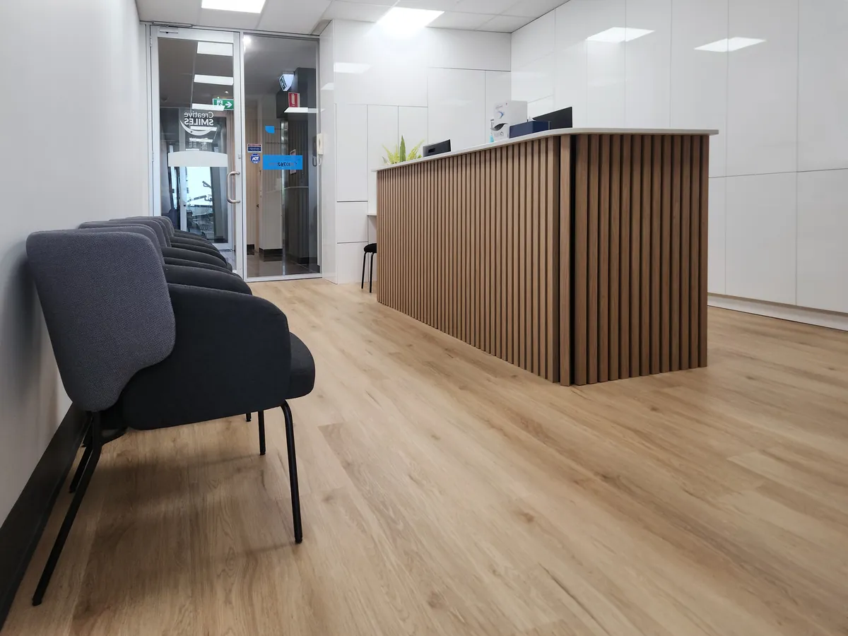 Waiting area seating beside the timber reception desk at the Creative Smiles dental clinic fitout, Armadale.