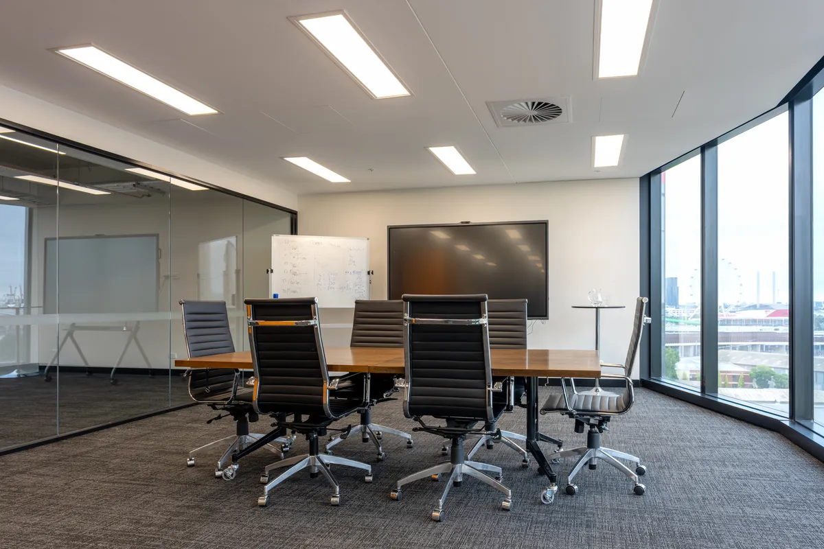 Boardroom with timber table, leather chairs and floor-to-ceiling windows at the Empower Wealth office fitout, North Melbourne.