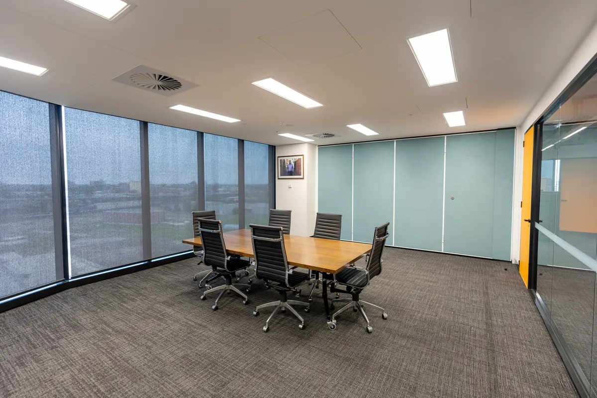 Meeting room with timber table, operable wall and floor-to-ceiling windows at the Empower Wealth office fitout, North Melbourne.