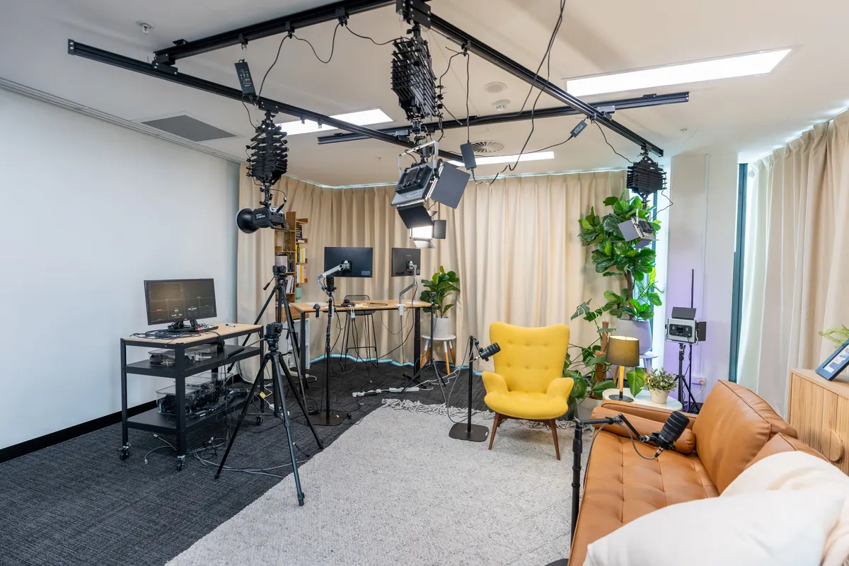 Podcast studio set with overhead lighting rig, microphones and feature seating at the Empower Wealth office fitout, North Melbourne.