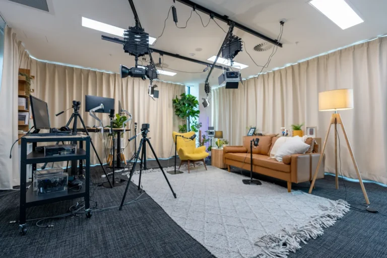 Podcast studio with lighting rig, cameras, leather sofa and yellow armchair at the Empower Wealth office fitout, North Melbourne.