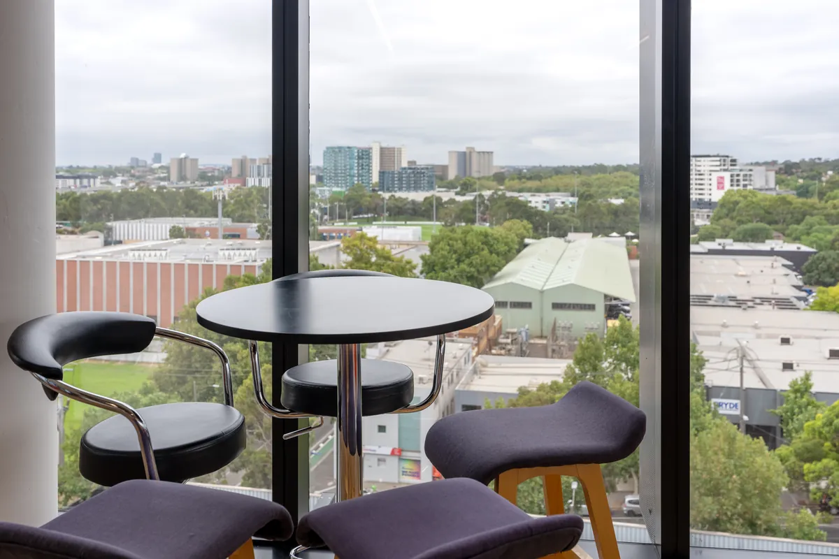 Window bar seating with high stools and city views at the Empower Wealth office fitout, North Melbourne.