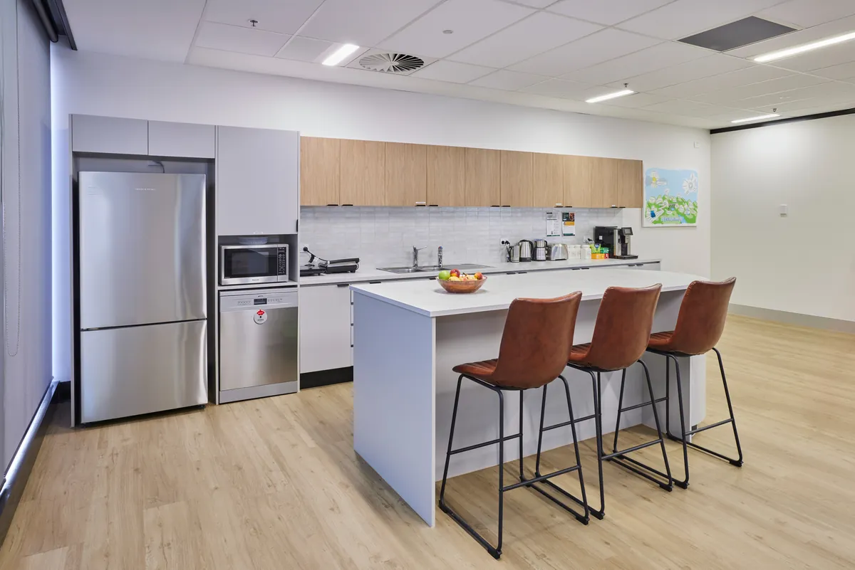 Kitchen with island bench, stools and appliances at the Endress and Hauser office fitout, Mulgrave.