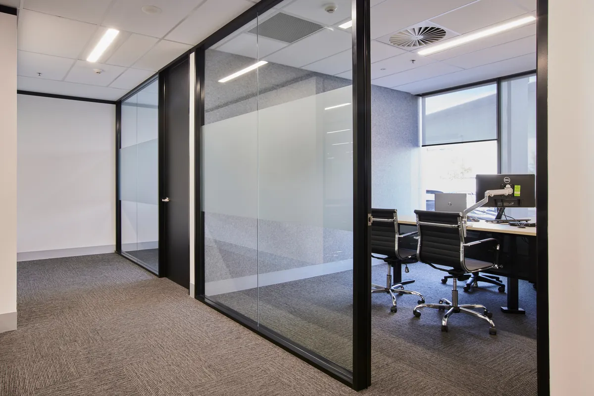 Glass-partitioned meeting room with workstations at the Endress and Hauser office fitout, Mulgrave.