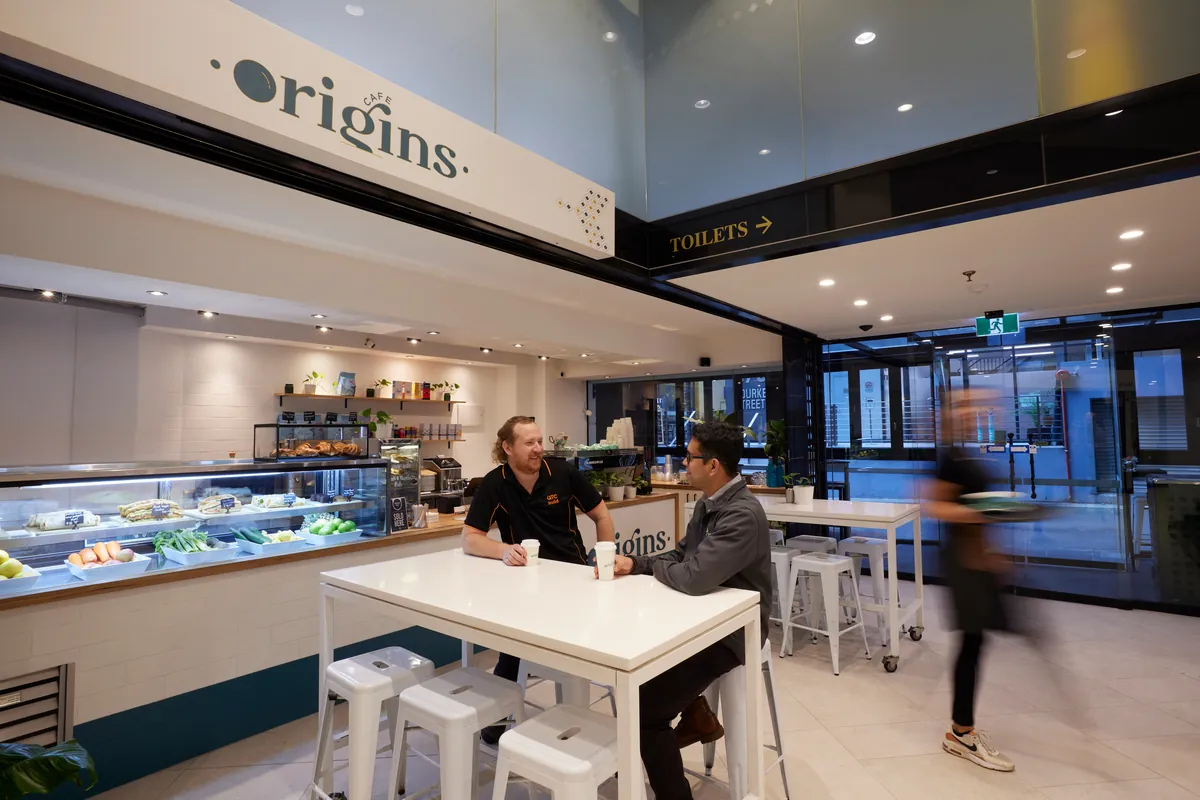 Origins cafe with display counter and communal seating at the Exchange Tower office refurbishment, Melbourne.