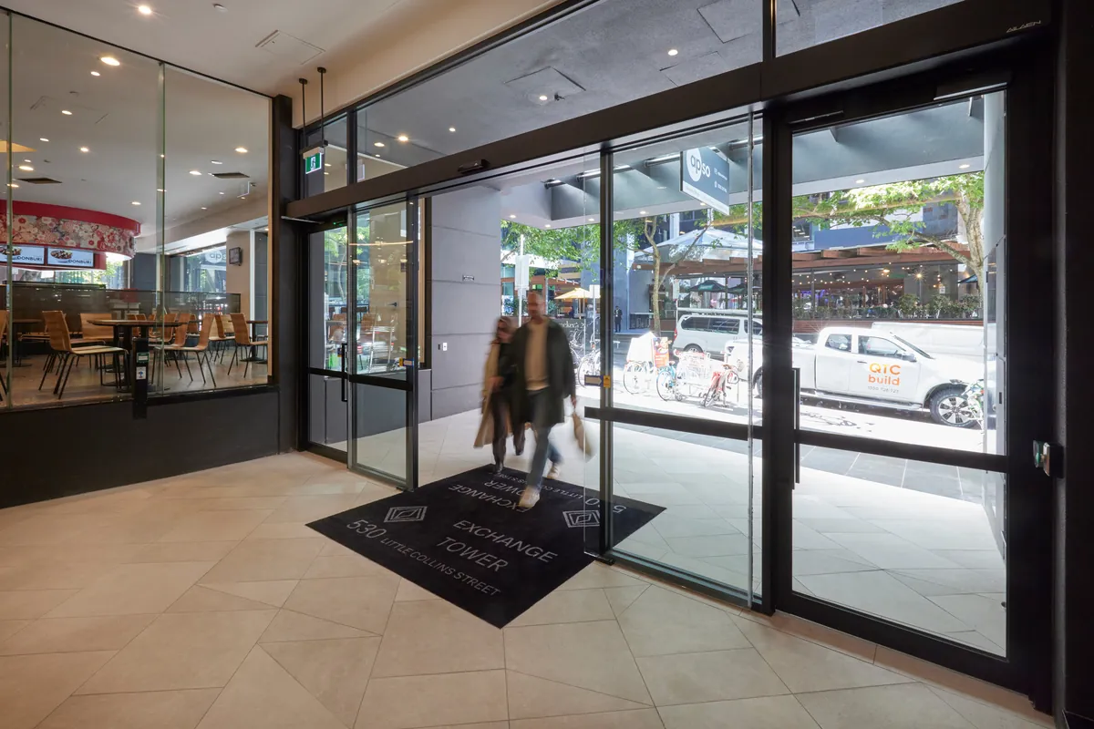 Tenants walking through the glazed street entrance of the Exchange Tower office refurbishment, Melbourne.