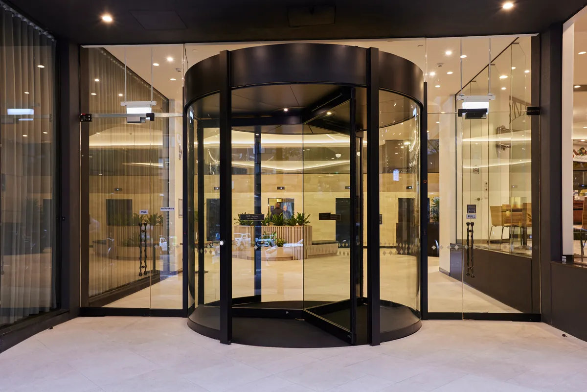 Black revolving entry door with full-height glazing at the Exchange Tower office refurbishment, Melbourne.