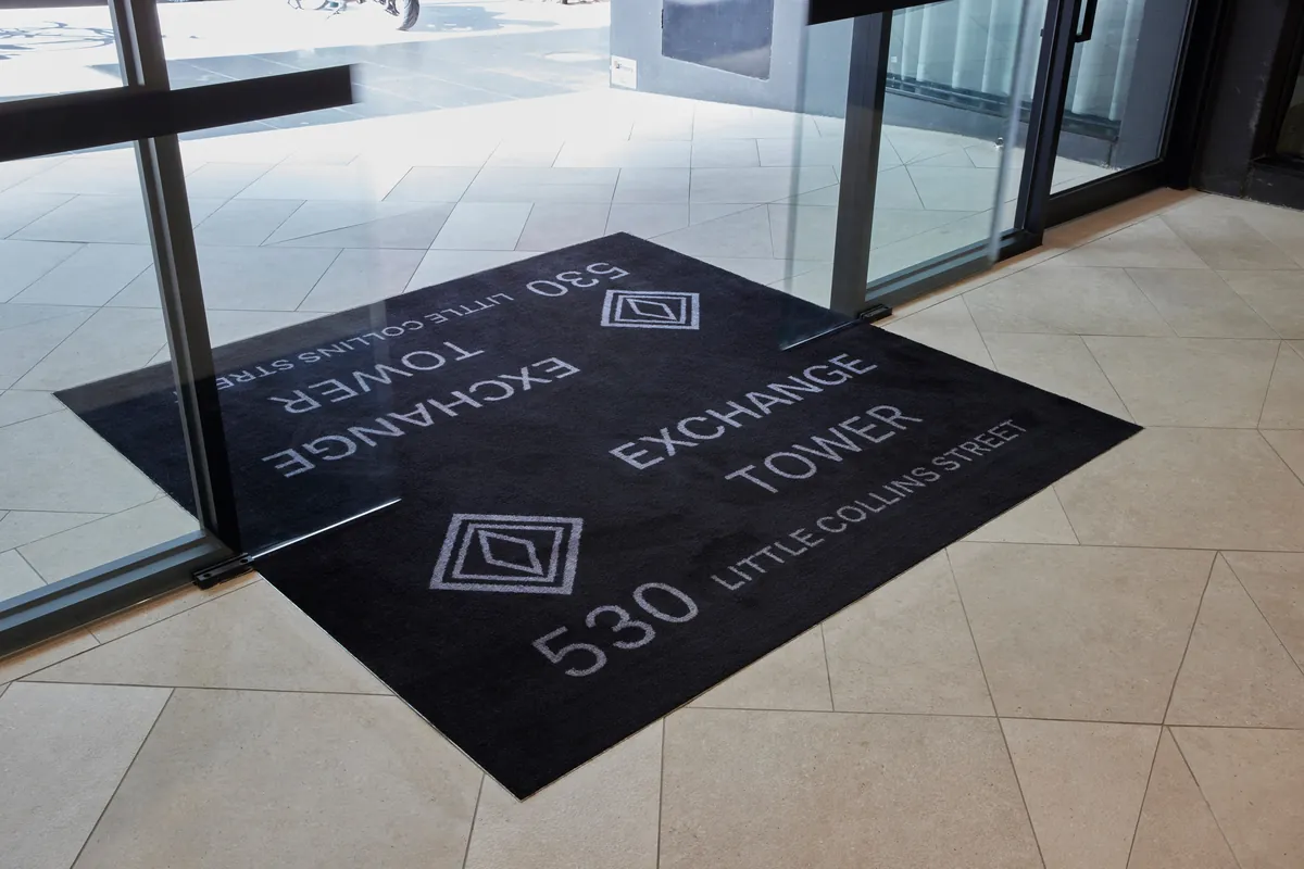 Branded entry mat reading Exchange Tower 530 Little Collins Street at the office refurbishment, Melbourne.