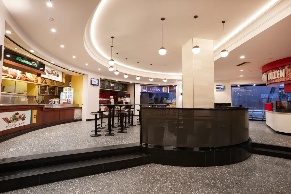 Refurbished food court with curved bar seating and pendant lighting at Exchange Tower, Melbourne.