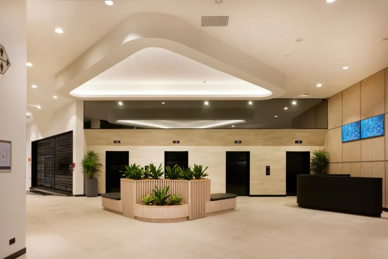 Refurbished lobby with lift cores, curved timber planter and feature ceiling at Exchange Tower, Melbourne.