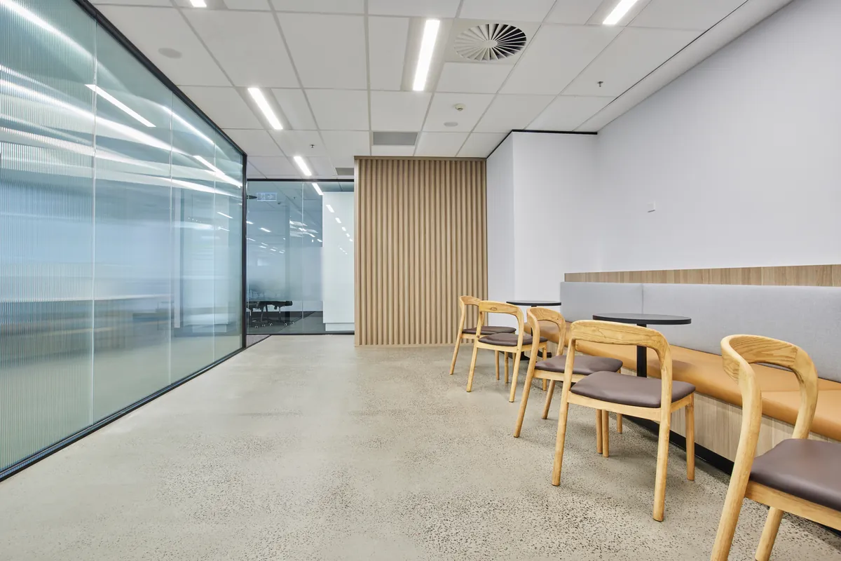 Breakout dining beside a fluted glass meeting room, Growthpoint spec suite fitout, Mulgrave.