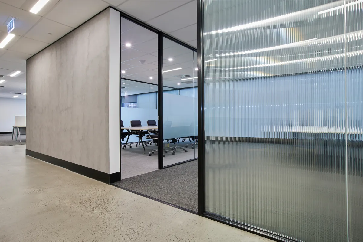 Glass-partitioned meeting room with concrete-look feature wall, Growthpoint spec suite fitout, Mulgrave.