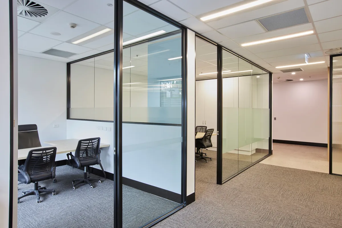 Glass-partitioned meeting rooms with workstations beyond, Growthpoint spec suite fitout, Mulgrave.