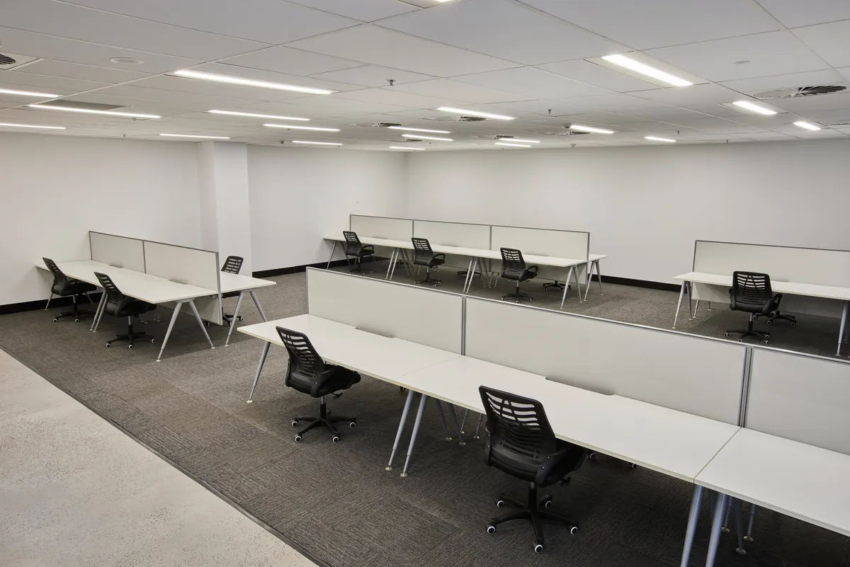 Open-plan workstations with white desks and screen dividers, Growthpoint spec suite fitout, Mulgrave.