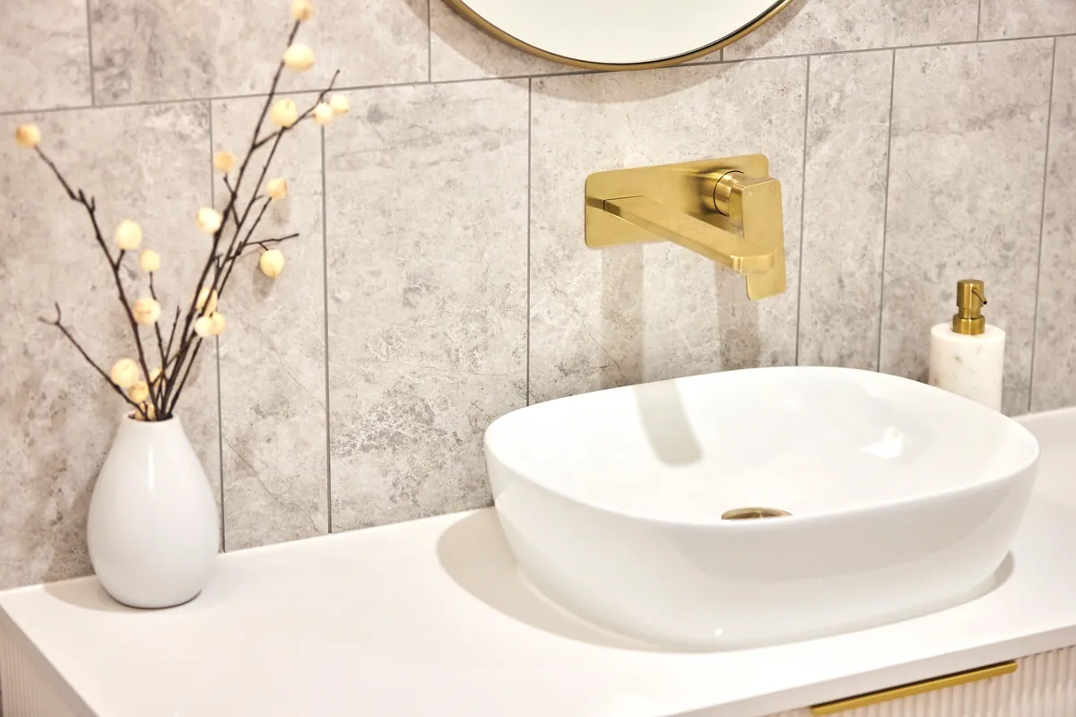 Vessel basin with brass wall tapware and tiled amenities at the Kew Periodontics dental clinic fitout, Kew.
