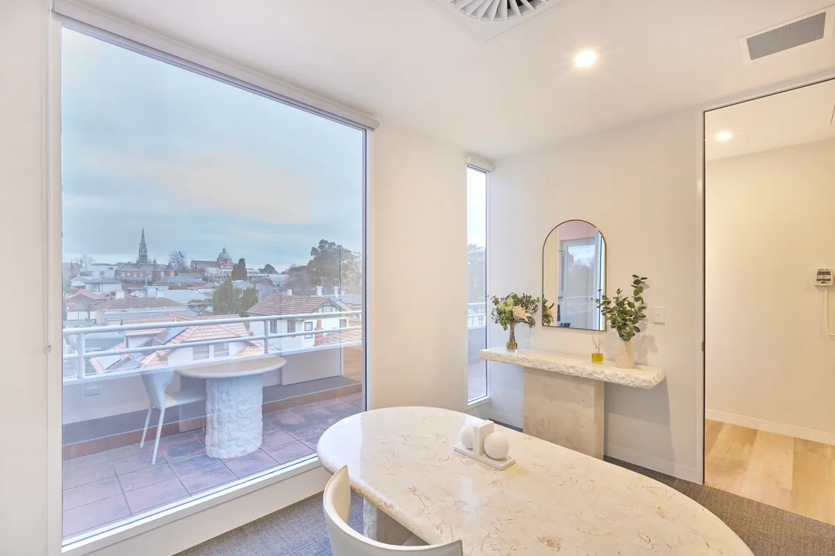 Consult room with marble table and balcony views at the Kew Periodontics dental clinic fitout, Kew.