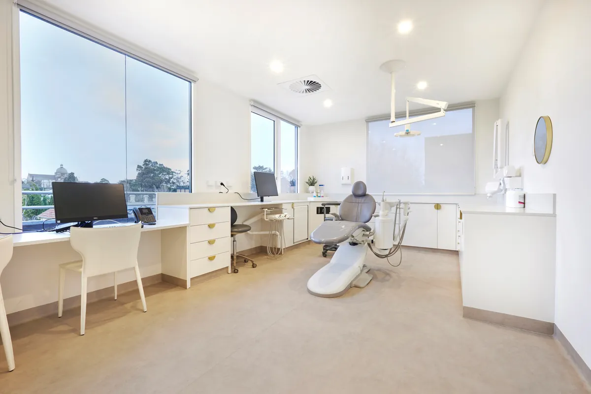 Dental surgery with treatment chair and window workstation at the Kew Periodontics dental clinic fitout, Kew.