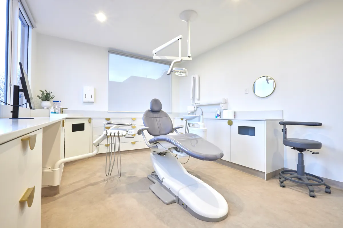 Dental surgery with treatment chair, overhead light and clinician stool, Kew Periodontics dental clinic fitout, Kew.