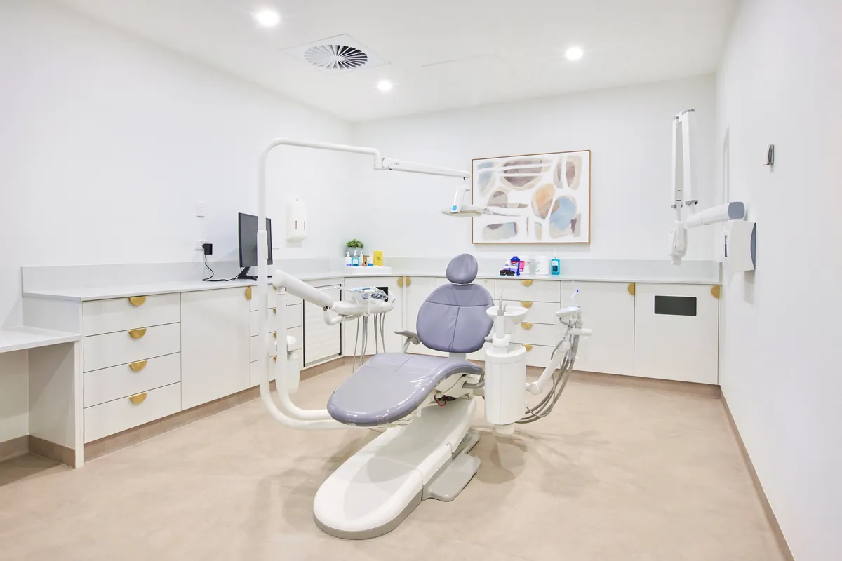 Dental surgery with treatment chair and custom joinery at the Kew Periodontics dental clinic fitout, Kew.