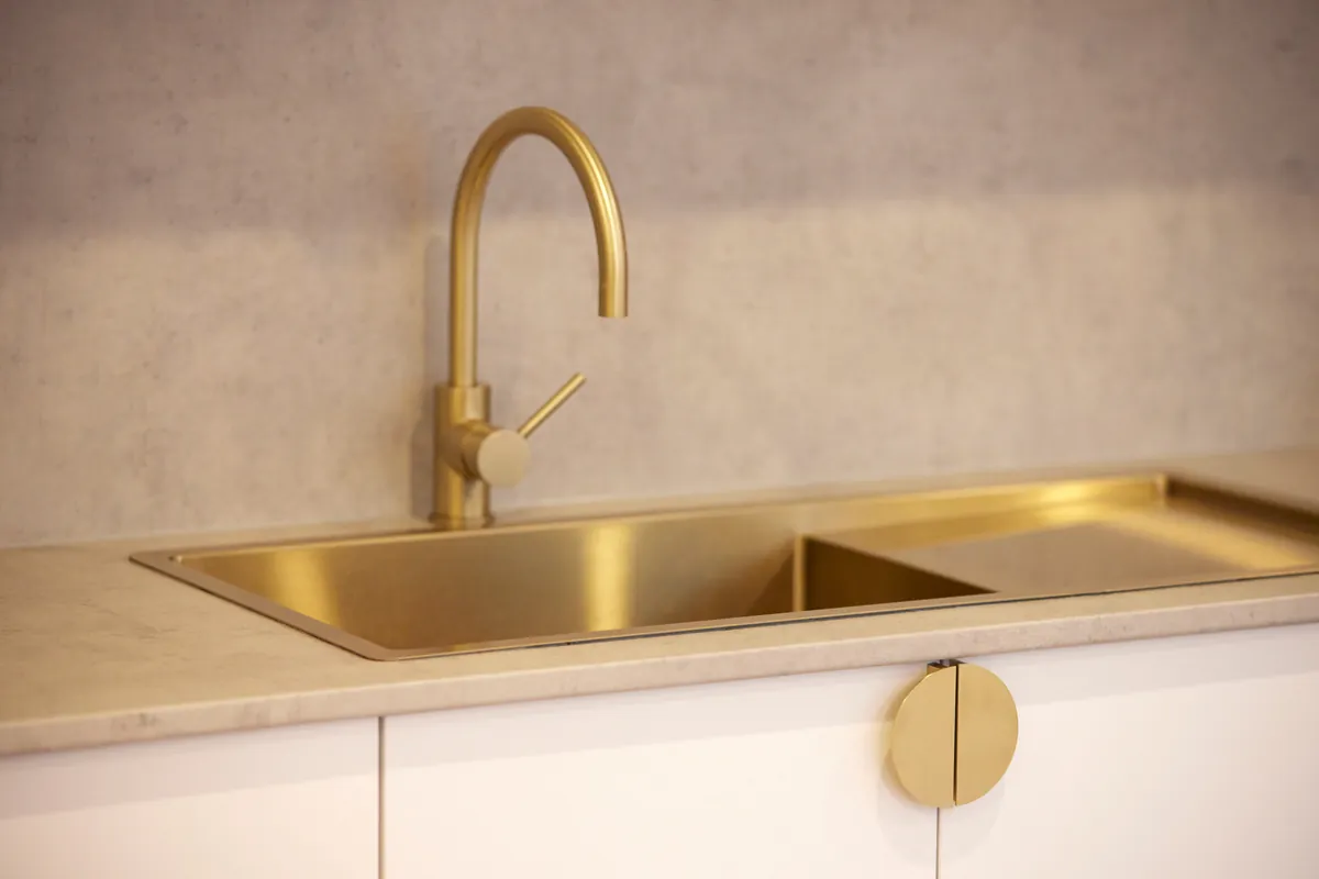 Brass sink and tapware with stone benchtop detail at the Kew Periodontics dental clinic fitout, Kew.