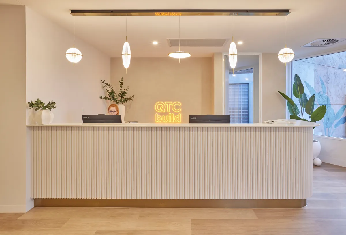 Fluted reception desk with QTC Build neon signage at the Kew Periodontics dental clinic fitout, Kew.
