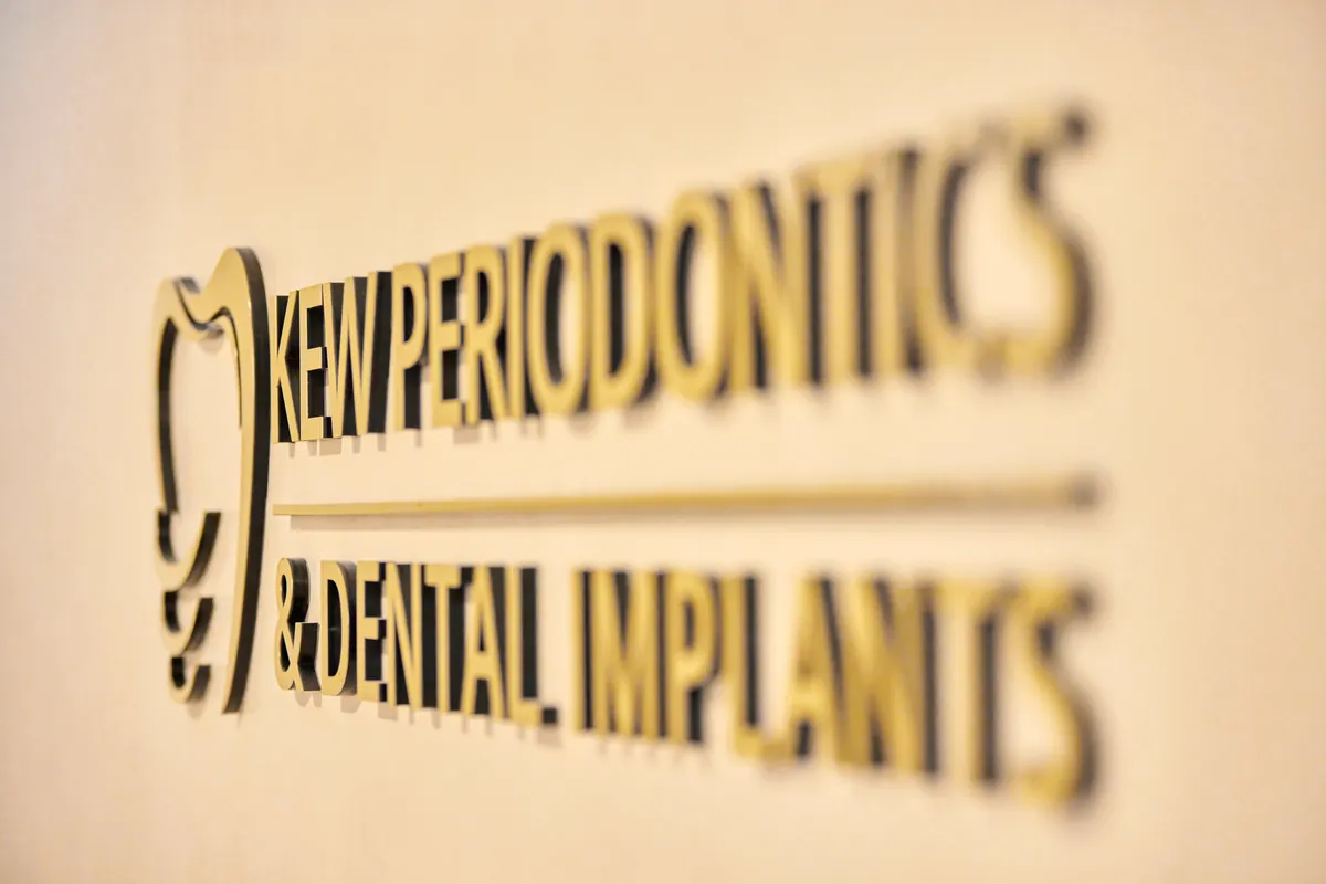 Brass Kew Periodontics signage detail on rendered wall at the dental clinic fitout, Kew.