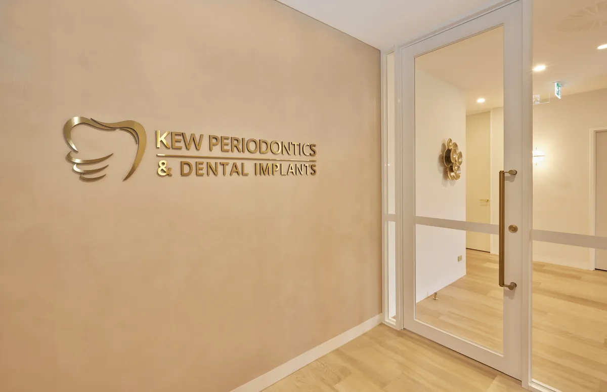 Brass entry signage on rendered wall at the Kew Periodontics dental clinic fitout, Kew.