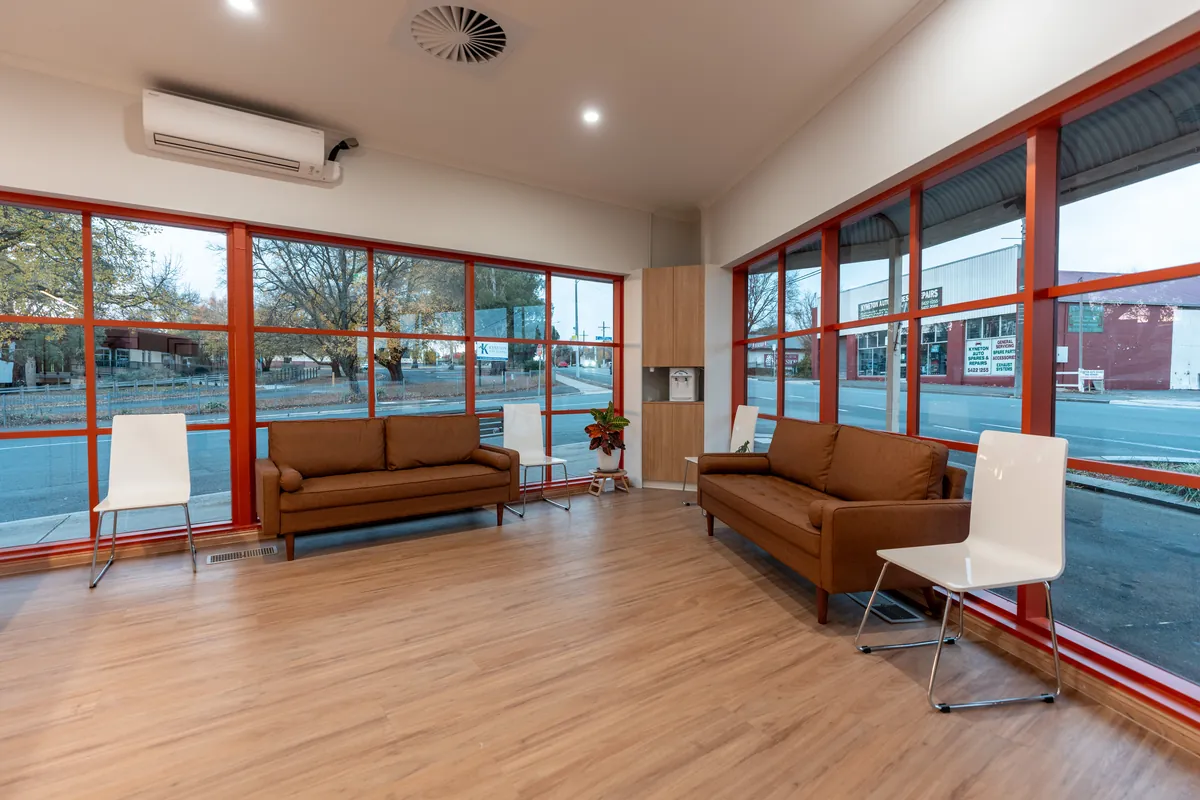 Bright waiting area with lounge seating and full-height windows at the Kyneton Dental dental clinic fitout, Kyneton.