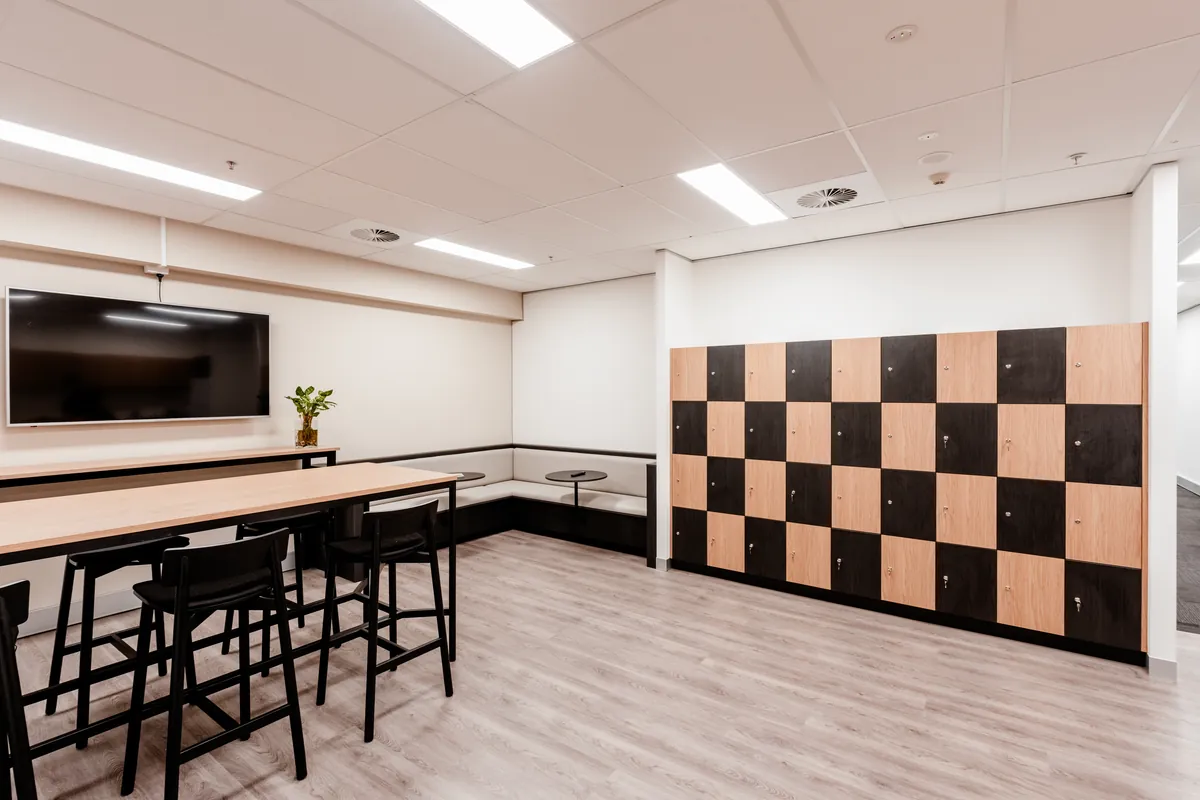 Breakout space with high bench, banquette seating and storage lockers at the McLarens office fitout, Melbourne.
