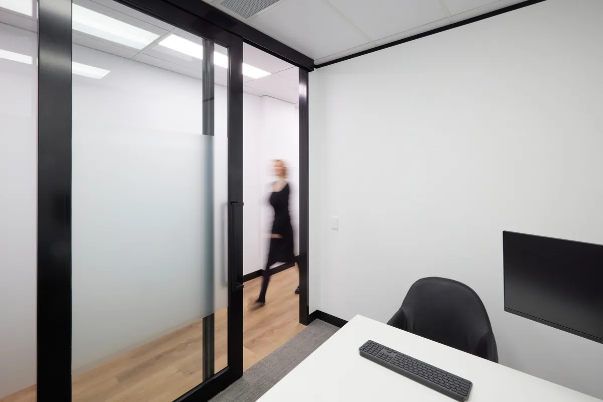 Private consult room with desk and glass partition sliding door, Melbourne Smiles dental clinic fitout, North Caulfield.