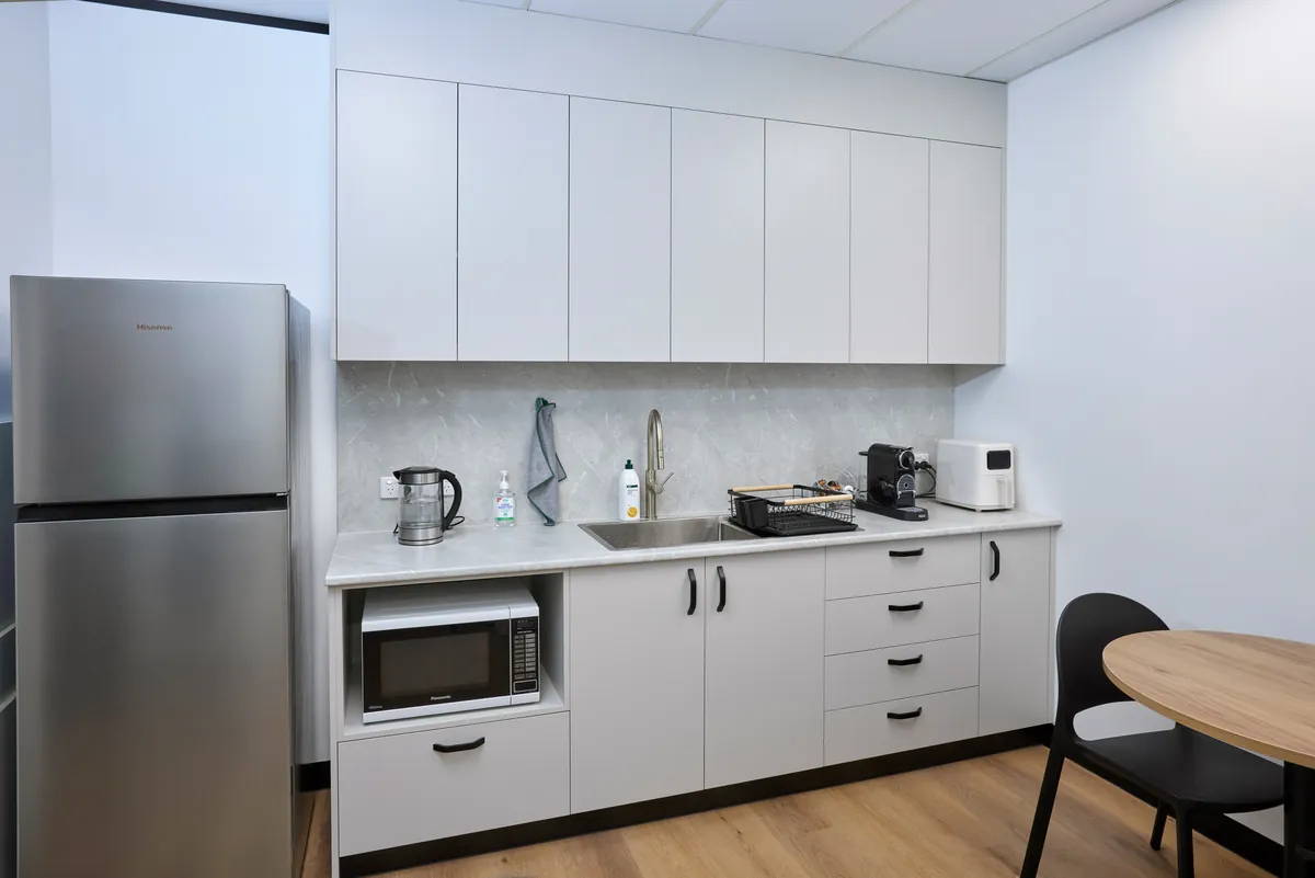 Staff kitchenette with sink, microwave and overhead joinery at the Melbourne Smiles dental clinic fitout, North Caulfield.