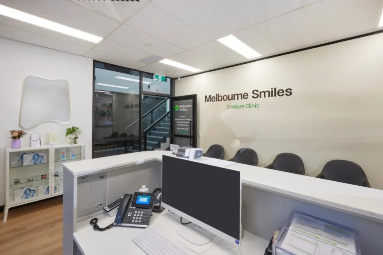 Reception desk with display cabinets and branded wall at the Melbourne Smiles dental clinic fitout, North Caulfield.