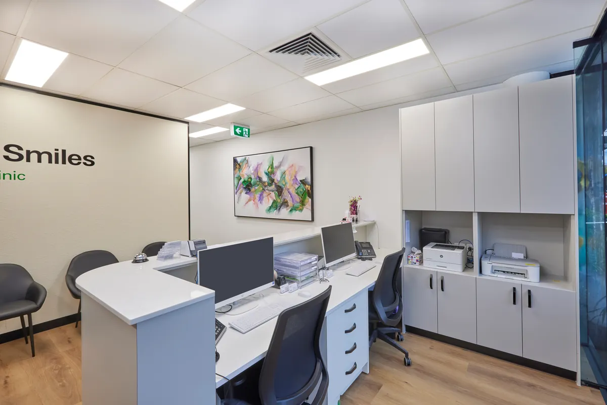 Curved reception desk with admin workstations at the Melbourne Smiles dental clinic fitout, North Caulfield.