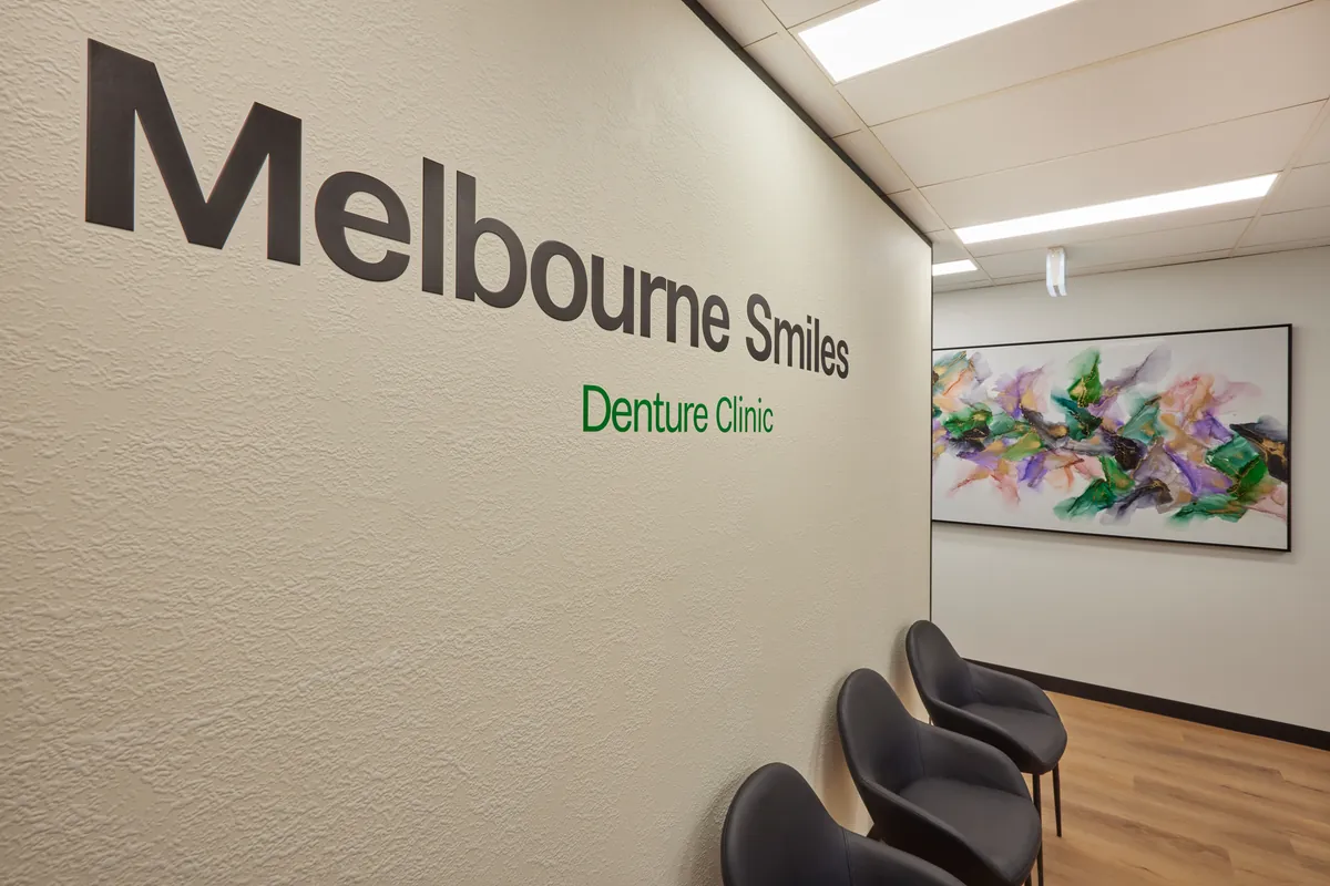 Branded feature signage wall with waiting seating at the Melbourne Smiles dental clinic fitout, North Caulfield.