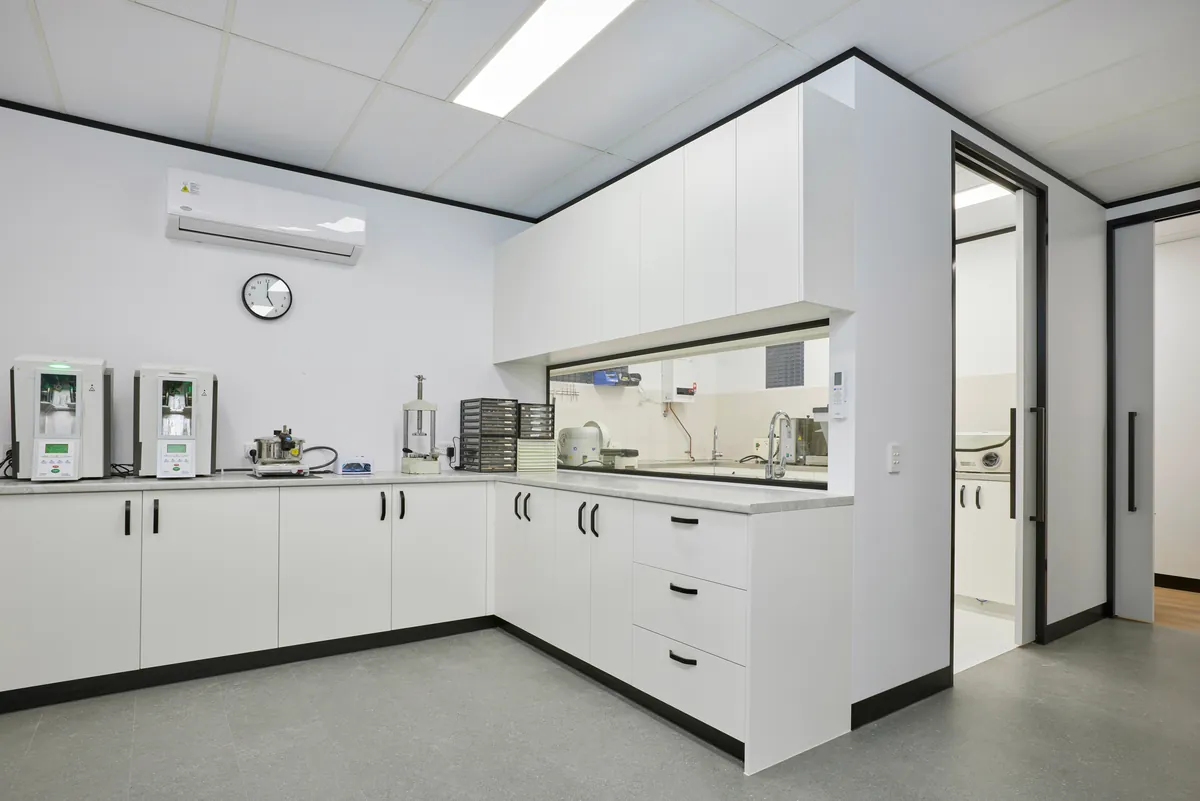 Sterilisation room with corner joinery and servery window in the Melbourne Smiles dental clinic fitout, North Caulfield.