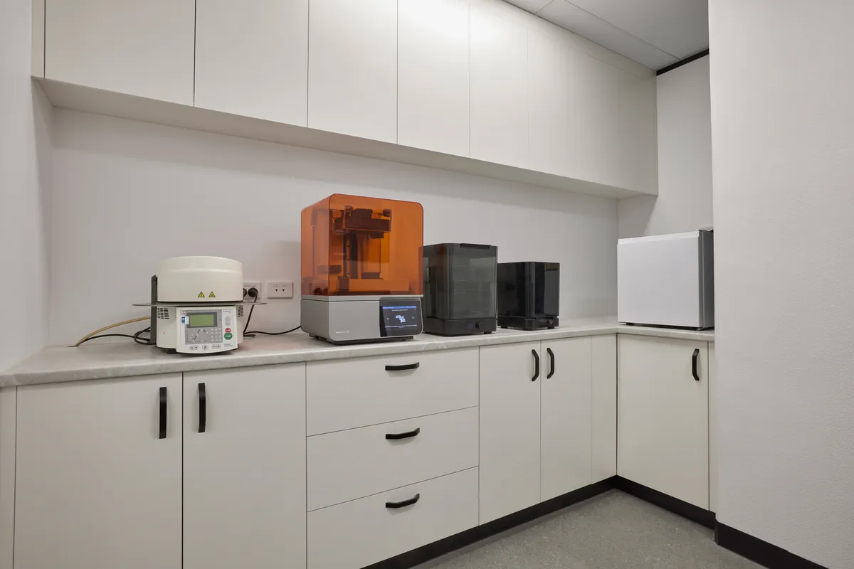 3D printing and curing equipment on stone benchtop in the Melbourne Smiles dental clinic fitout, North Caulfield.