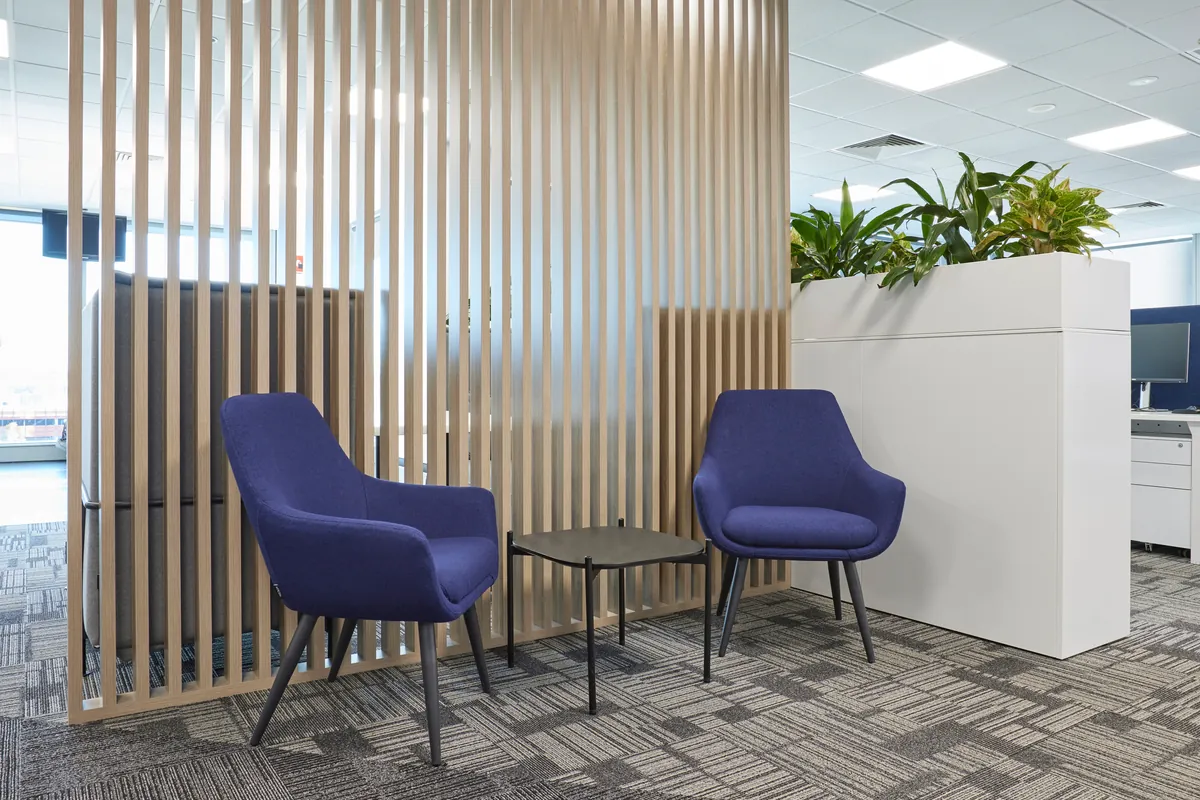 Waiting nook with blue armchairs and timber batten screen at the Navantia office fitout, Docklands.