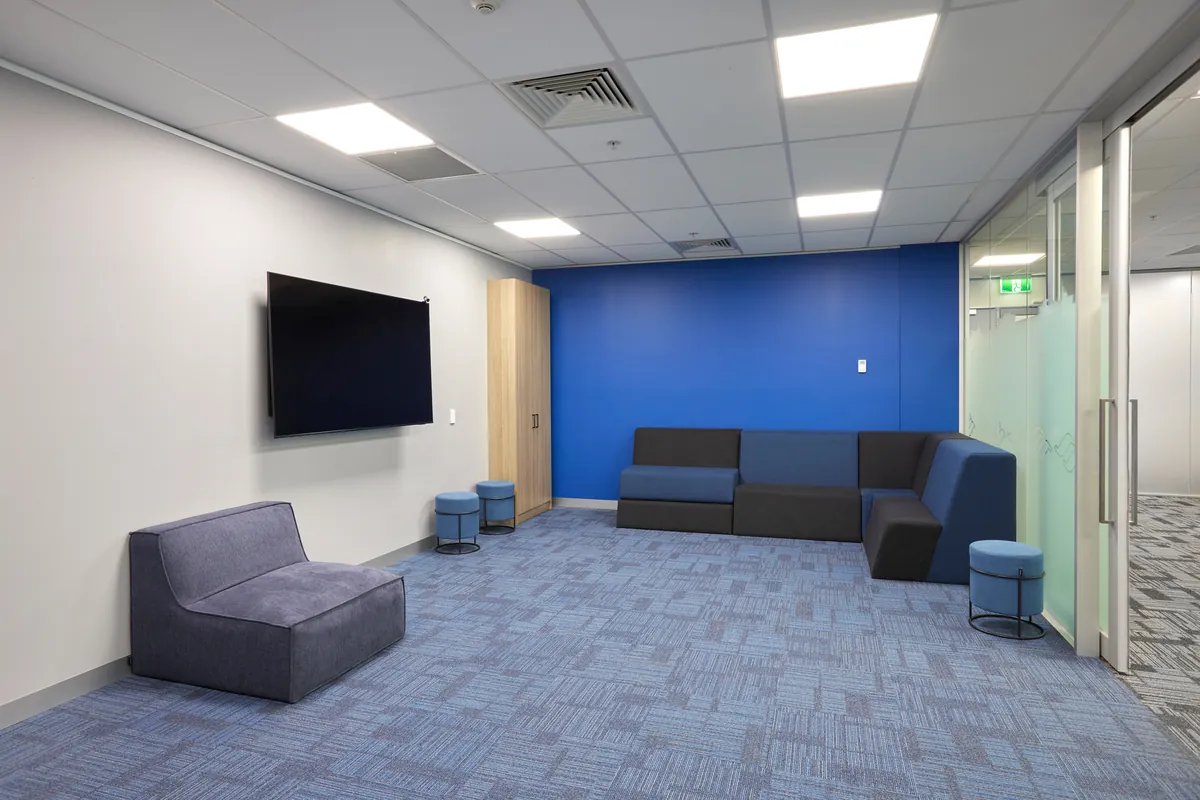 Breakout lounge with modular sofa, ottomans and screen at the Navantia office fitout, Docklands.
